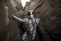 Spaceman exploring nameless planet, examining canyon — Stock Photo