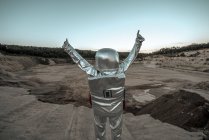 Spaceman raising arms on nameless planet, with thumbs up — Stock Photo