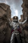 Spaceman exploring nameless planet, examining canyon — Stock Photo