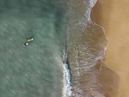 Indonesia, Bali, Aerial view of Pandawa beach, two surfers in the ocean — Stock Photo