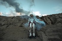 Homem espacial abandonado dando sinais de fumaça no deserto — Fotografia de Stock