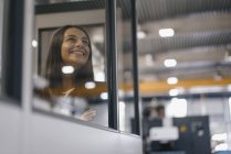 Mujer segura que trabaja en la empresa de alta tecnología, mirando fuera de la sala de control - foto de stock