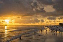USA, Florida, Fort Myers, silhouettes of Fort Myers Beach and tourists with a huge rain cloud above during sunset — Stock Photo