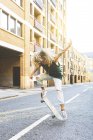 Молода жінка робить трюки з скейтборд в місті — Stock Photo