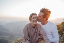 Suisse, Grosser Mythen, jeune couple heureux en randonnée faisant une pause au lever du soleil — Photo de stock