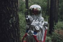 Spaceman exploring nature, filming trees in forest — Stock Photo