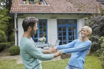 Happy couple dancing in front of their home — Stock Photo