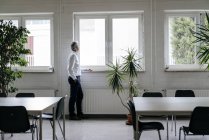 Homme d'affaires faisant une pause, regardant par la fenêtre — Photo de stock