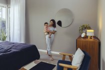 Sorridente madre che porta la sua bambina a casa — Foto stock
