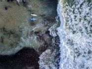 Indonesia, Bali, Vista aérea de la playa de Dreamland, tres surfistas desde arriba - foto de stock