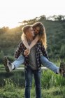 Романтична пара витрачає час на природу, обіймаючи на заході сонця — стокове фото