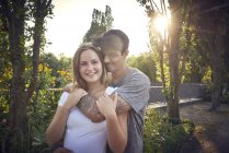 Happy young couple flirting in a park in summer — Stock Photo