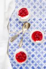 Yogurt greco con salsa di ribes rosso su piastrelle blu fantasia — Foto stock