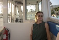 Donna con gli occhiali da sole seduta sulla barca — Foto stock