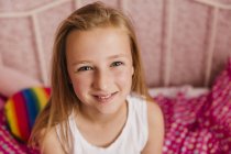Portrait of smiling little girl in bedroom — Stock Photo