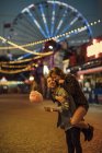 Casal jovem se divertindo em uma feira, comendo Candyfloss — Fotografia de Stock