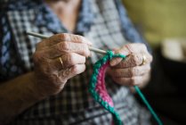 Руки пожилой женщины, вязание крючком, крупный план — стоковое фото