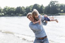 Father and son having fun at riverside — Stock Photo