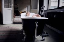 Donna che fa il bagno di bolle nel loft di design — Foto stock
