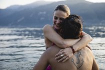 Счастливая молодая пара обнимается в озере — стоковое фото