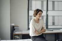 Exitosa mujer de negocios sentada en su oficina - foto de stock