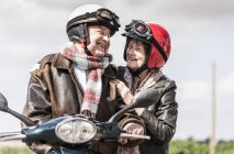 Glückliches Senioren-Paar fährt Motorroller auf Landstraße — Stockfoto