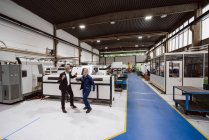 Manager e lavoratori qualificati che ballano in officina, divertendosi — Foto stock