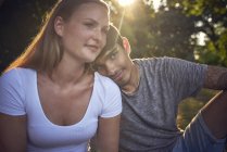 Romantic young couple sitting in park, enjoying sunset — Stock Photo