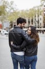 Spain, Barcelona, young couple embracing and walking in city — Stock Photo