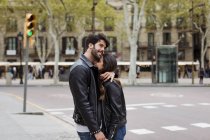 Happy young couple hugging on street — Stock Photo