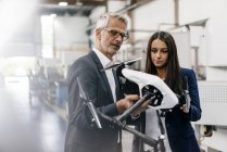 Empresário e empresária na empresa de alta tecnologia, discutindo a produção de drones — Fotografia de Stock