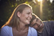 Romantic young couple sitting in park, enjoying sunset — Stock Photo