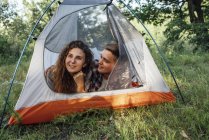 Jeune couple campant dans la nature, couché dans une tente — Photo de stock