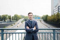 Retrato de empresário confiante em pé na ponte da auto-estrada — Fotografia de Stock