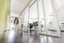 Businesswoman walking in corridor of office building — Stock Photo