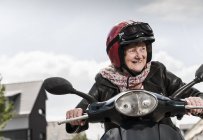 Scooter a motore attivo senior lady riding in città — Foto stock