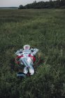 Spaceman relaxing on green meadow with hands behind head — Stock Photo