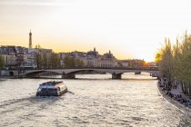Francia, Parigi, Pont du Carrousel con barca turistica al tramonto — Foto stock