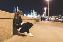 Россия, Москва, красивая женщина слушает музыку в городе ночью — стоковое фото