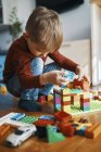 Little boy playing with building bricks on the floor at home — Stock Photo