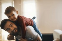 Portrait of happy father and little son playing together at home — Stock Photo