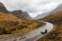 Regno Unito, Scozia, strada panoramica attraverso le montagne negli altopiani scozzesi vicino Glencoe con vista sulle Tre Sorelle — Foto stock