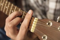 Close-up of man's hand playing guitar — Stock Photo