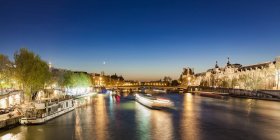 France, Paris, Pont du Carrousel with tourist boats at night — Stock Photo