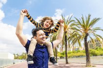 Spain, Barcelona, happy father carrying son on shoulders — Stock Photo