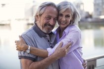 Senior couple taking a city break, kissing and embracing — Stock Photo