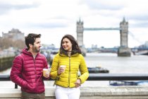 Великобритания, Лондон, пара с кофе, стоящая на мосту через Темзу — стоковое фото