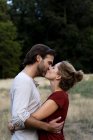 Affectionate couple kissing in nature — Stock Photo