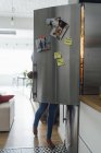 Hungry woman standing in kitchen, searching her fridge — Stock Photo
