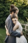 Novia y novio abrazando al aire libre - foto de stock